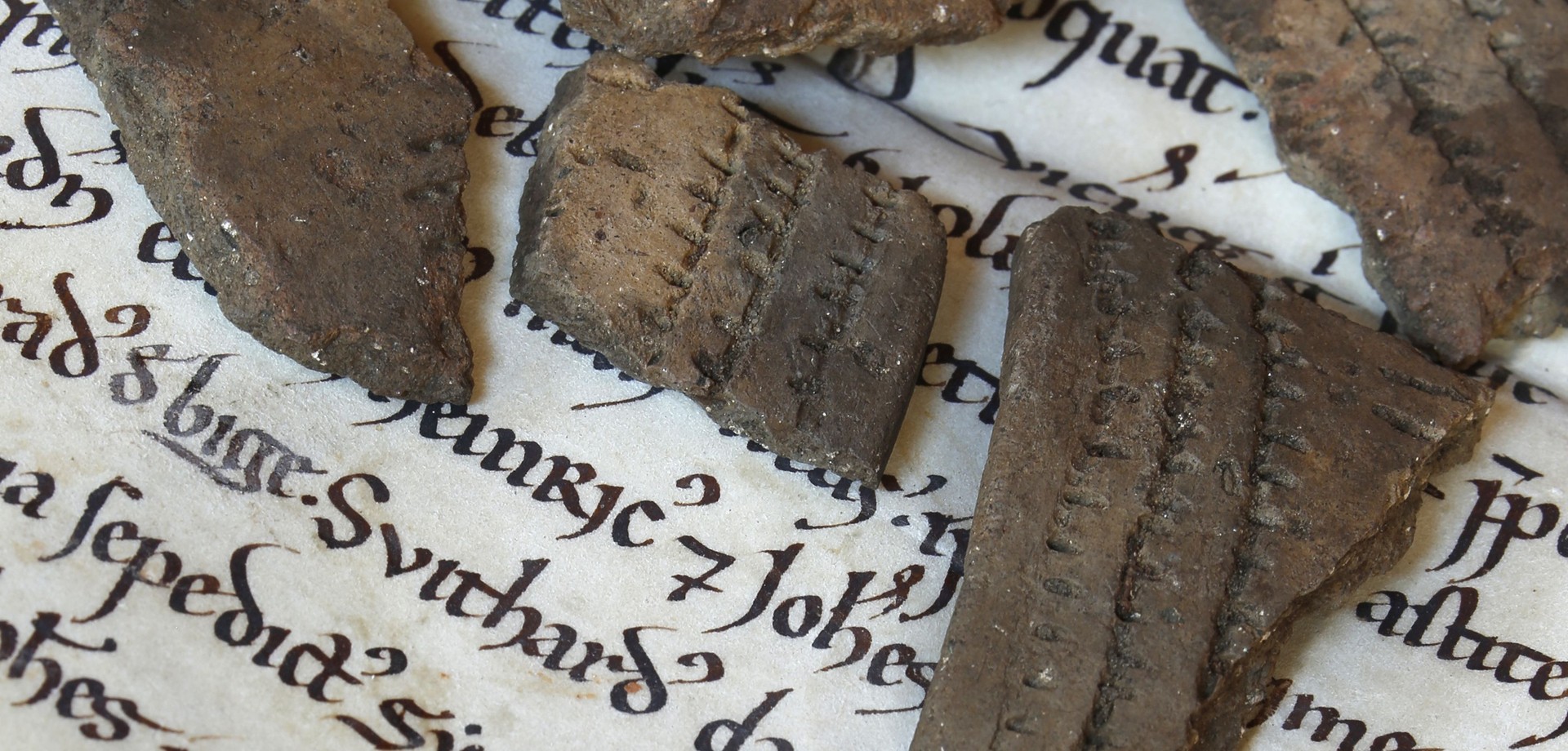 Keramikscherben liegen auf einer mittelalterlichen Urkunde (Foto: Historische Kommission für Westfalen).