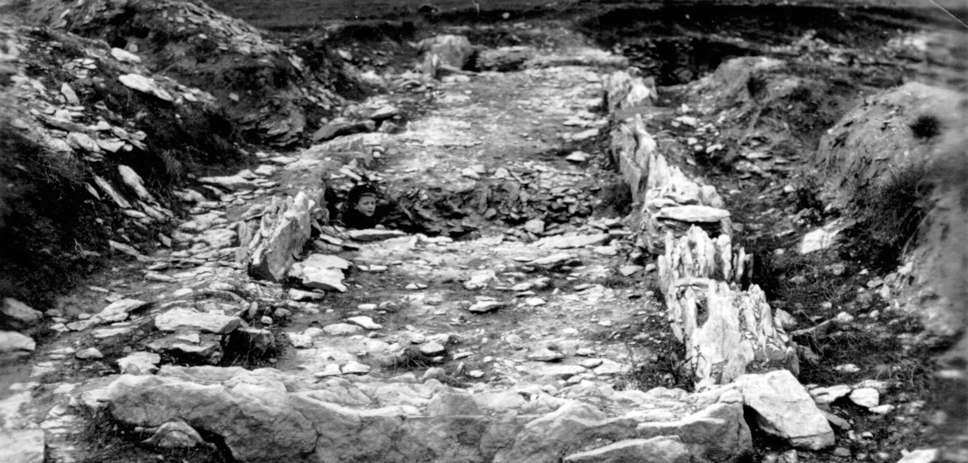 Das Grab in Soest-Hiddingsen nach der Freilegung 1934 mit einem kleinen Jungen, der im Schnitt sitzt (Bild: Stadtarchiv Soest).