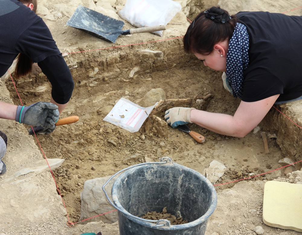 Studentinnen beim Freilegen von Knochenresten (Foto: Altertumskommission/Klinke).